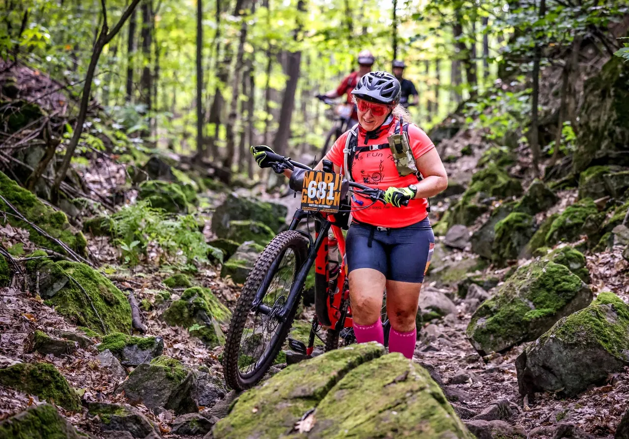 An active cyclist navigating a wooded trail